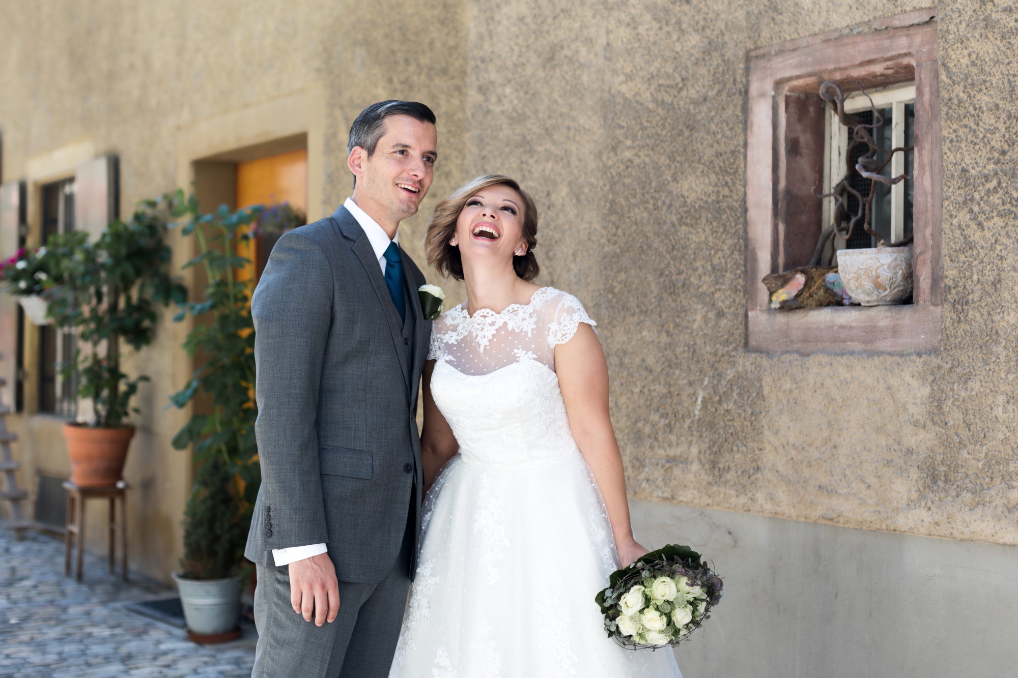 Das glückliche Brautpaar beim Brautpaar Fotoshooting in Rheinfelden. Die Braut lacht herzhaft.