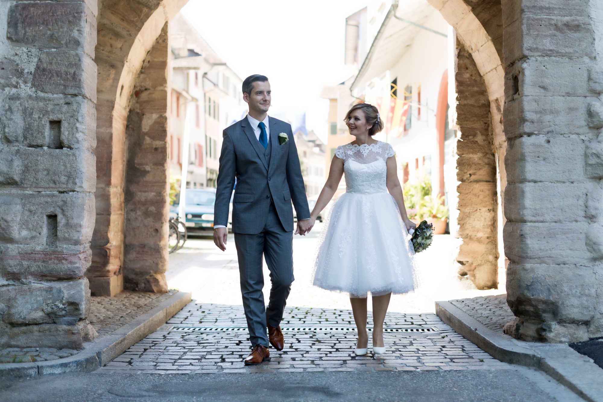 Das Brautpaar spaziert durch das Tor in Rheinfelden