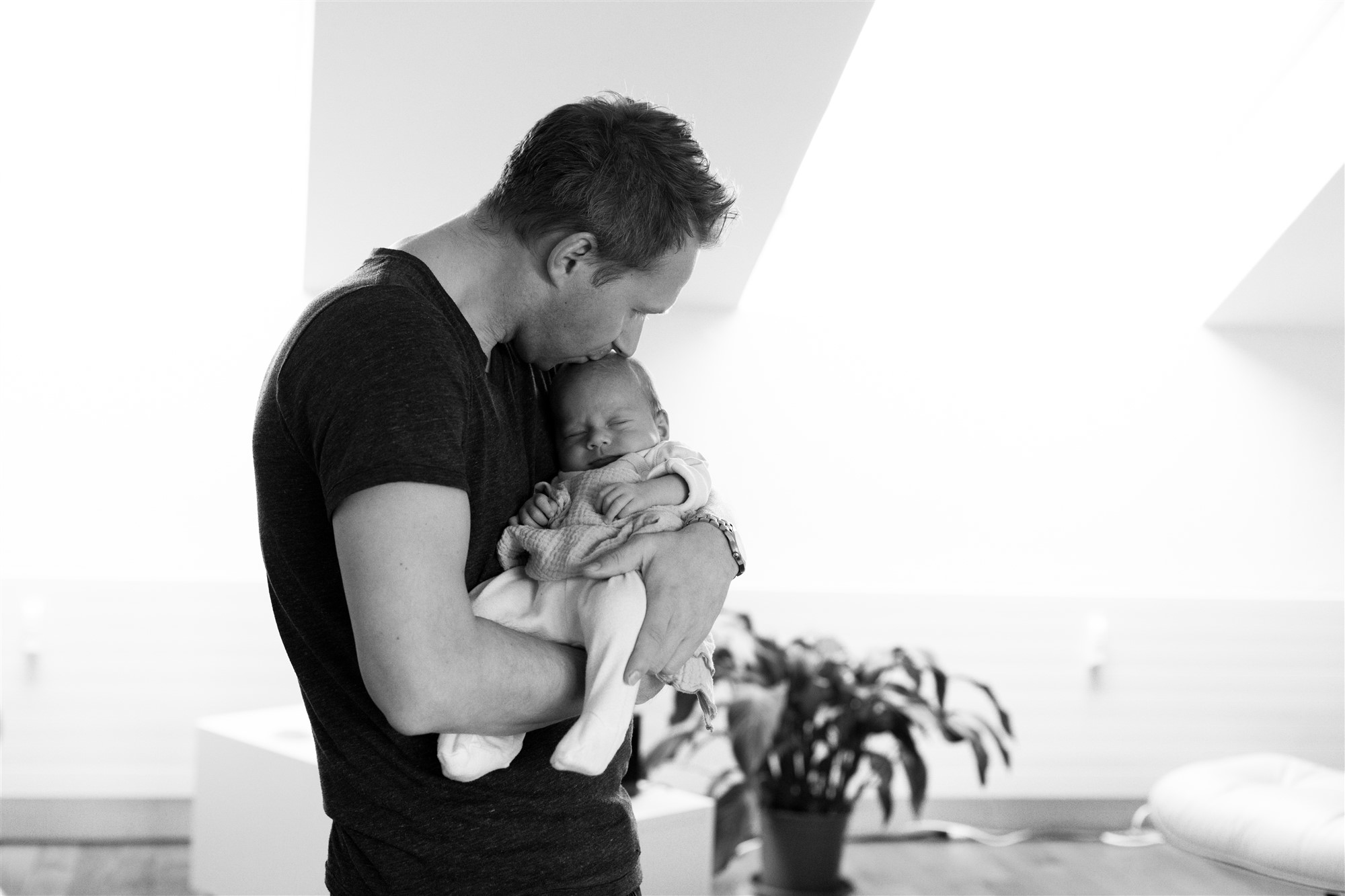 Newborn Homestory Fotoshooting - Der stolze Papa mit seinem Baby