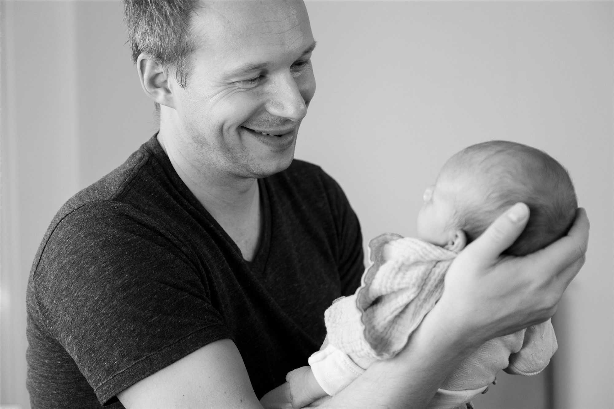 Newborn Homestory Fotoshooting - Der stolze Papa mit seinem Baby