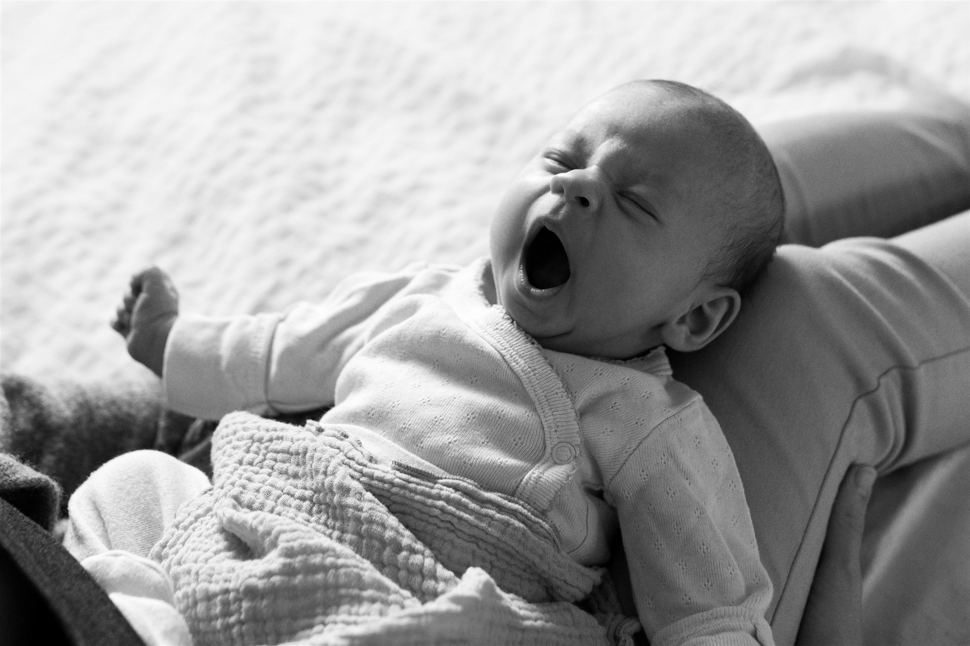 Newborn Homestory Fotoshooting - Die Mama kuschelt mit ihrem Baby