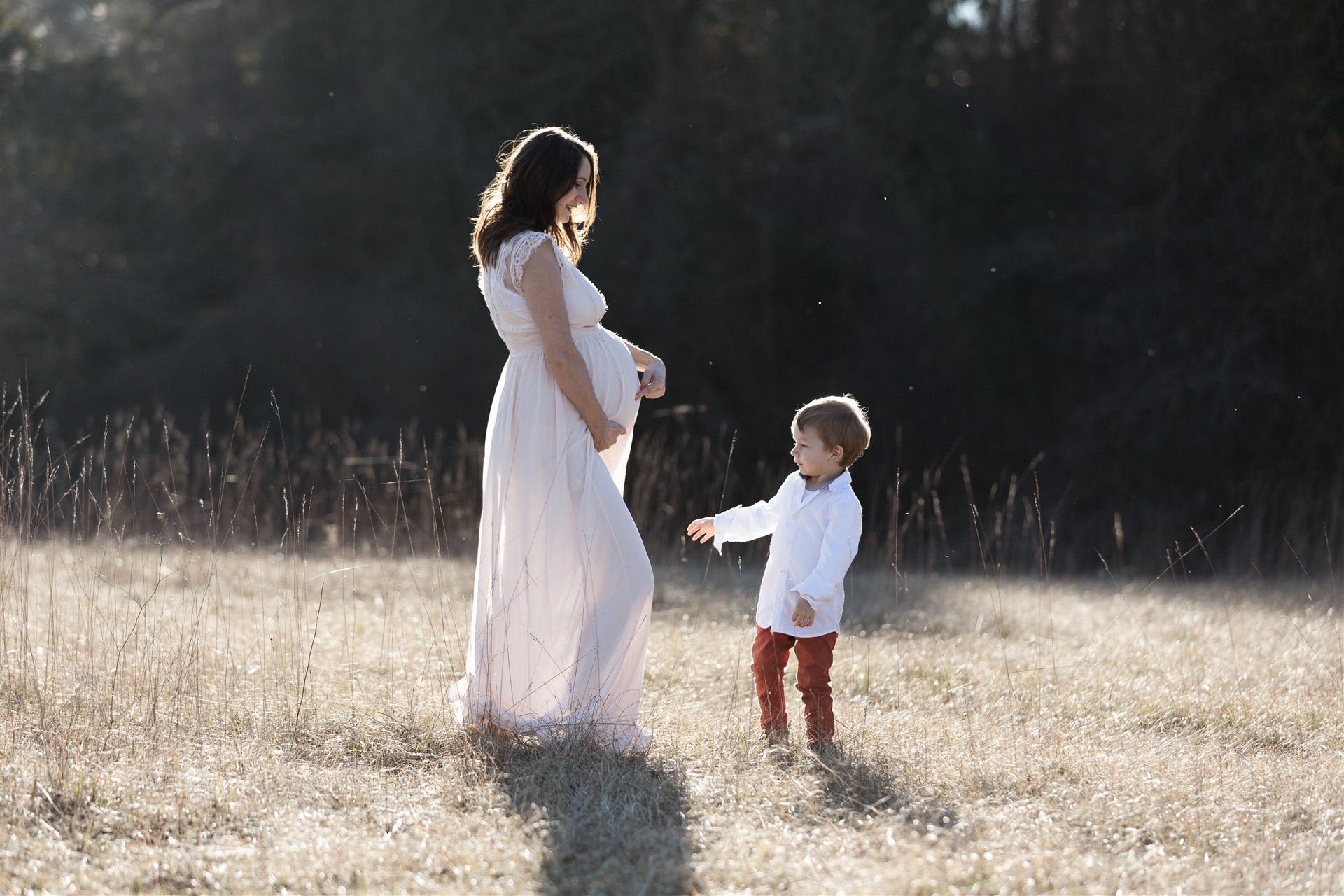 Babybauch Fotoshooting in der Natur mit der werdenden Mama und ihrem kleinen Sohn