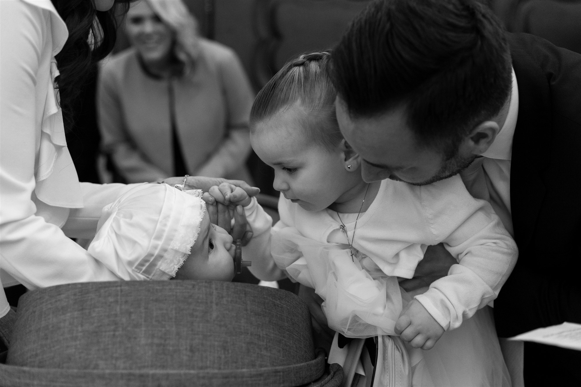 Die grosse Schwester segnet das Taufbaby