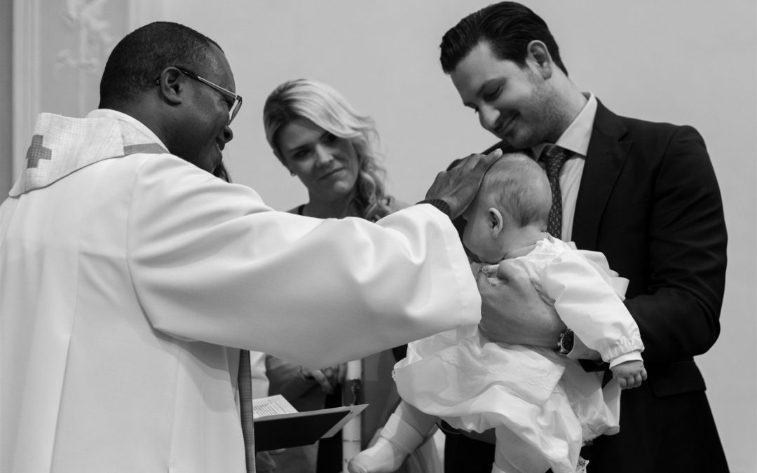 Tauf Reportage - Der Pfarrer segnet das Baby bei der Taufe in Arlesheim