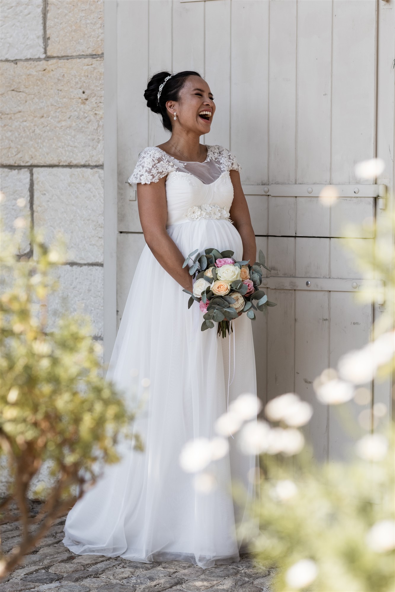 Die lachende Braut und ihr Babybauch beim romantischen Fotoshooting in den Merian Gärten