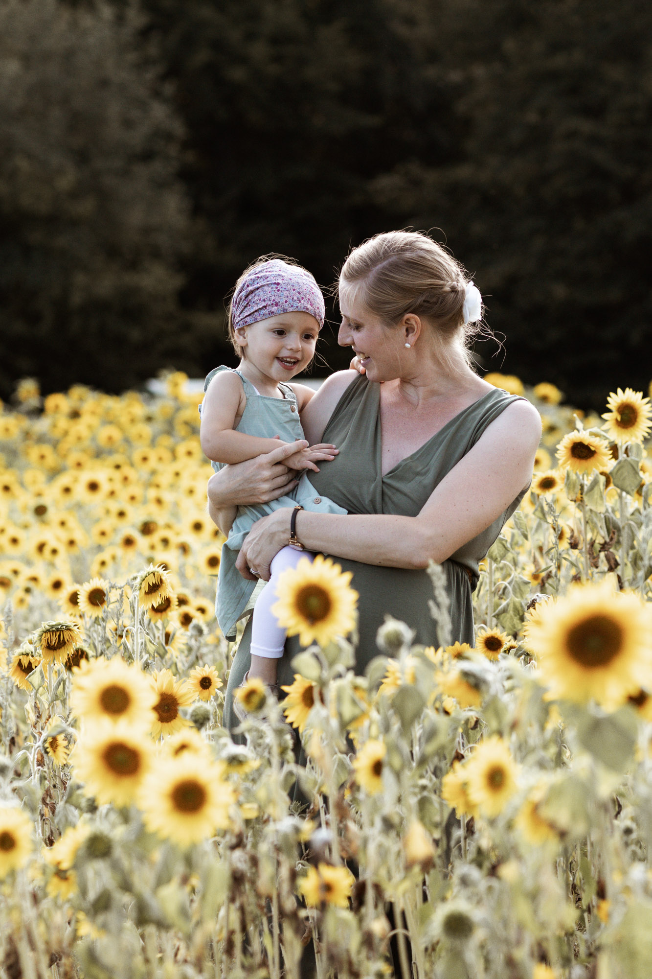 Babybauch und Familienfotoshooting in den Merian Gärten - Die Mama mit ihrer süssen Tochter im Sonnenblumenfeld