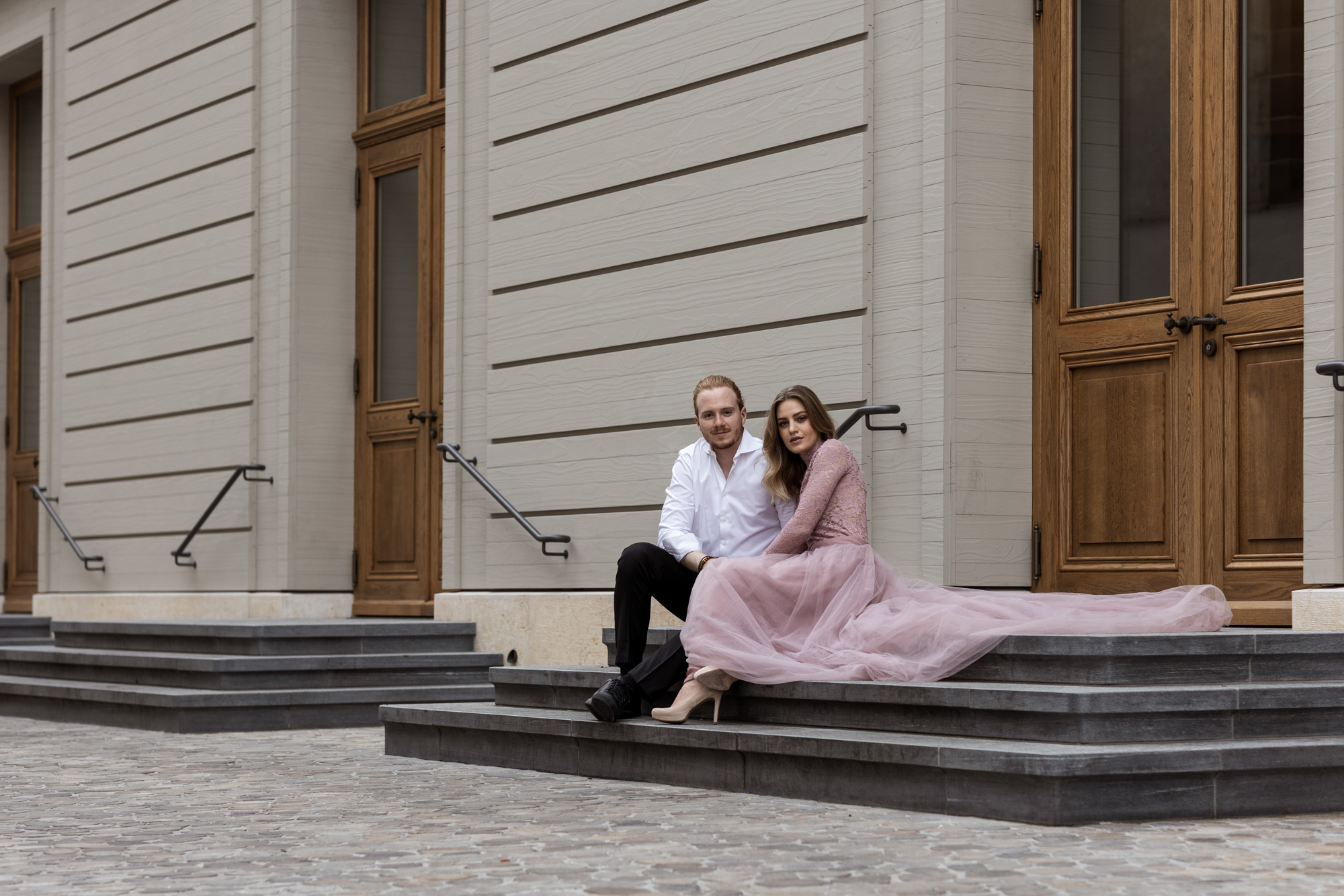Engagement Fotoshooting beim Stadtcasino in Basel - Das Paar sitzt auf der Treppe - Fotograf Nicole.Gallery