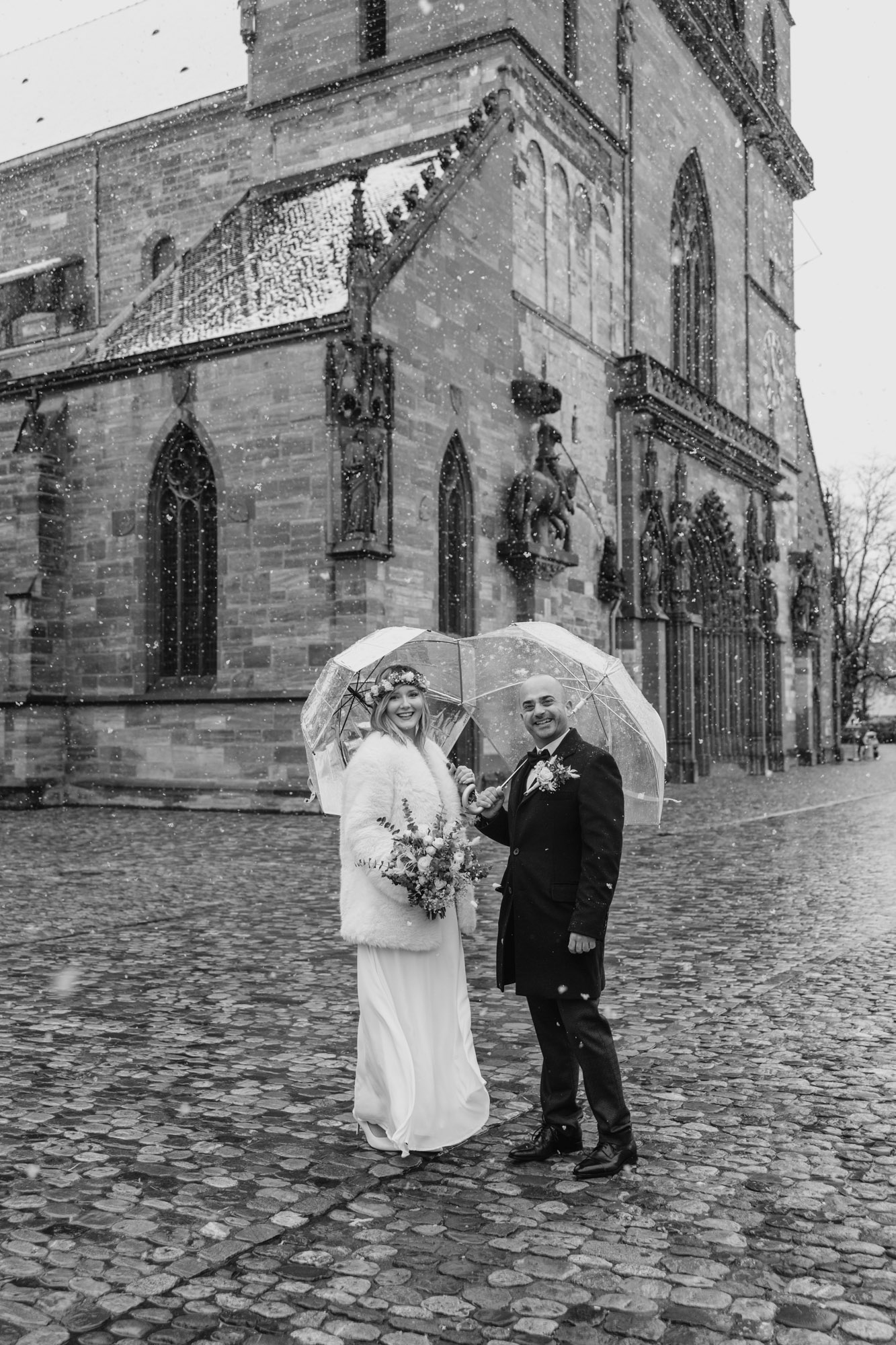 überglückliches Hochzeitspaar inmitten von Schneeflocken - Hochzeitsfotograf Basel